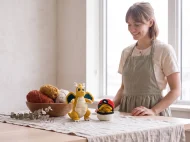 dragonite reversible crochet pattern — the finished Dragonite plush and its crocheted ball on a linen covered table in the studio