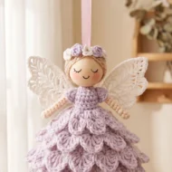 Crochet angel ornament pattern hanging on its ribbon in soft daylight
