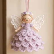 Finished crochet angel ornament pattern displayed against a cream wall