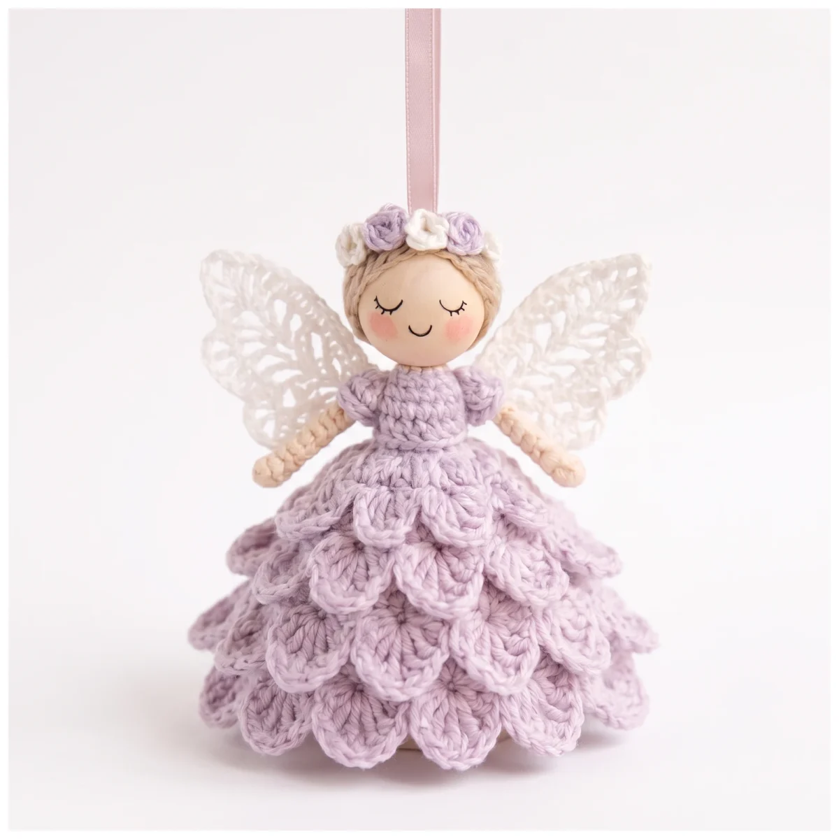 Crochet angel ornament pattern — the finished lace-wing angel on a pink ribbon