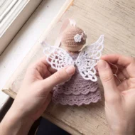 Sewing the lace wings on while making the crochet angel ornament pattern