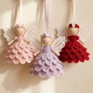 Crochet angel ornament pattern worked in three colourways: blush, lilac and deep red