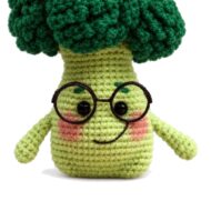crochet broccoli pattern - face close-up of the amigurumi baby broccoli wearing wire glasses