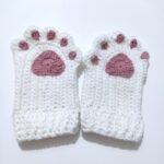 The finished pair from the crochet cat paw gloves pattern, cream gloves with dusty-rose paw pads and toe pads