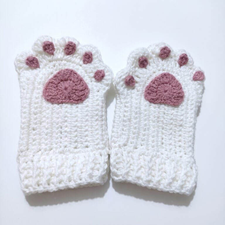 The finished pair from the crochet cat paw gloves pattern, cream gloves with dusty-rose paw pads and toe pads