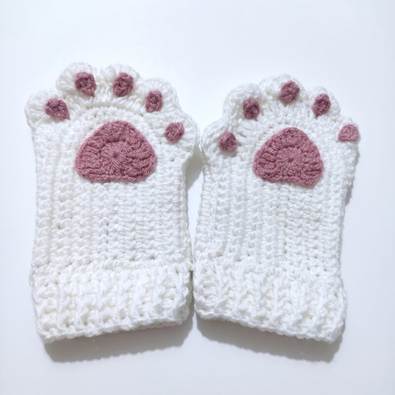 The finished pair from the crochet cat paw gloves pattern, cream gloves with dusty-rose paw pads and toe pads