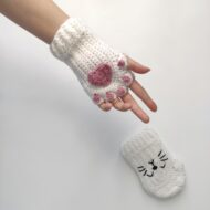 One glove from the crochet cat paw gloves pattern worn on a hand, the second showing its stitched cat face