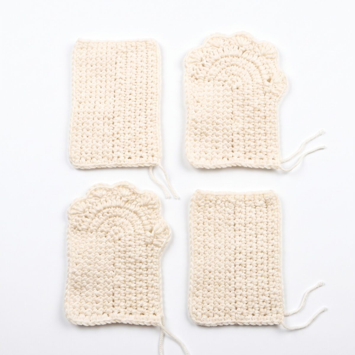 The four identical flat pieces of the crochet cat paw gloves pattern before they are sewn into a pair
