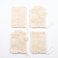 The four identical flat pieces of the crochet cat paw gloves pattern before they are sewn into a pair