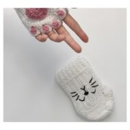The black stitched cat face on the back of the hand, from the crochet cat paw gloves pattern