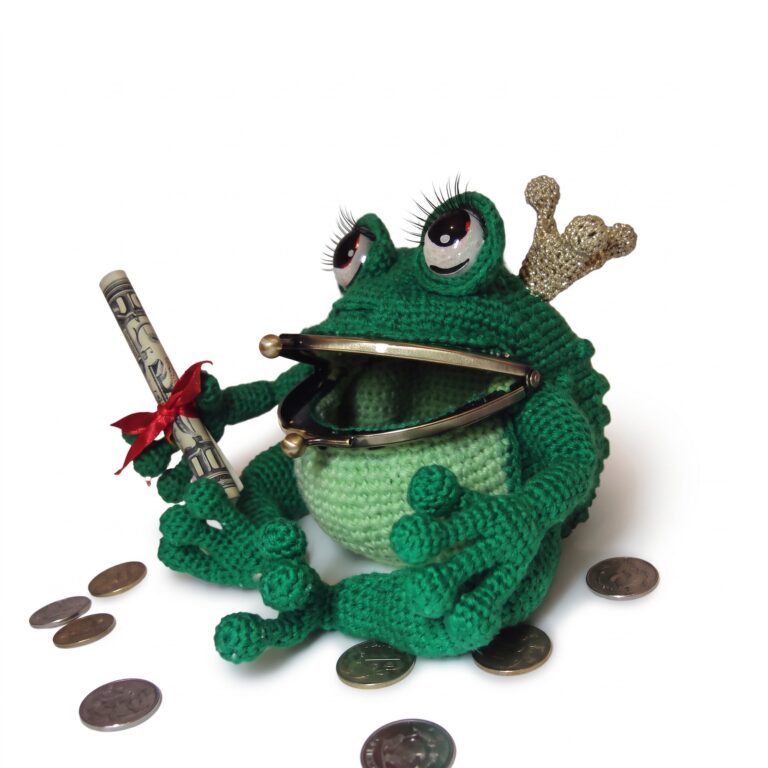 The crochet frog purse pattern seen at a three-quarter angle, showing the crown, the lashed eyes and the bobbled back