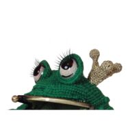 Close-up of the lashed eyes and little gold crown of the crochet frog purse pattern