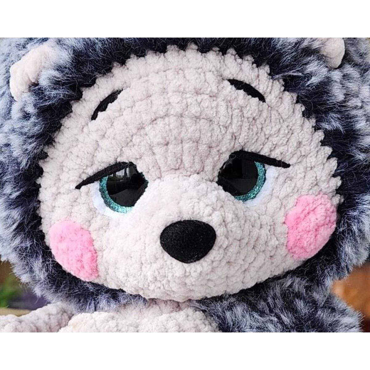 Close-up of the sculpted face, teal eyes and pink cheeks from the crochet hedgehog pattern