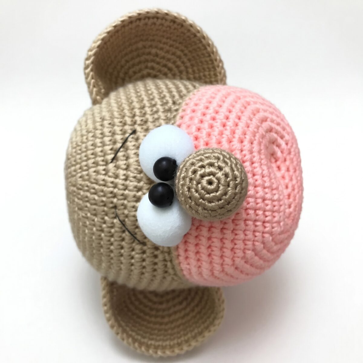 Close-up of the face, pink muzzle and eyes from the crochet monkey pattern