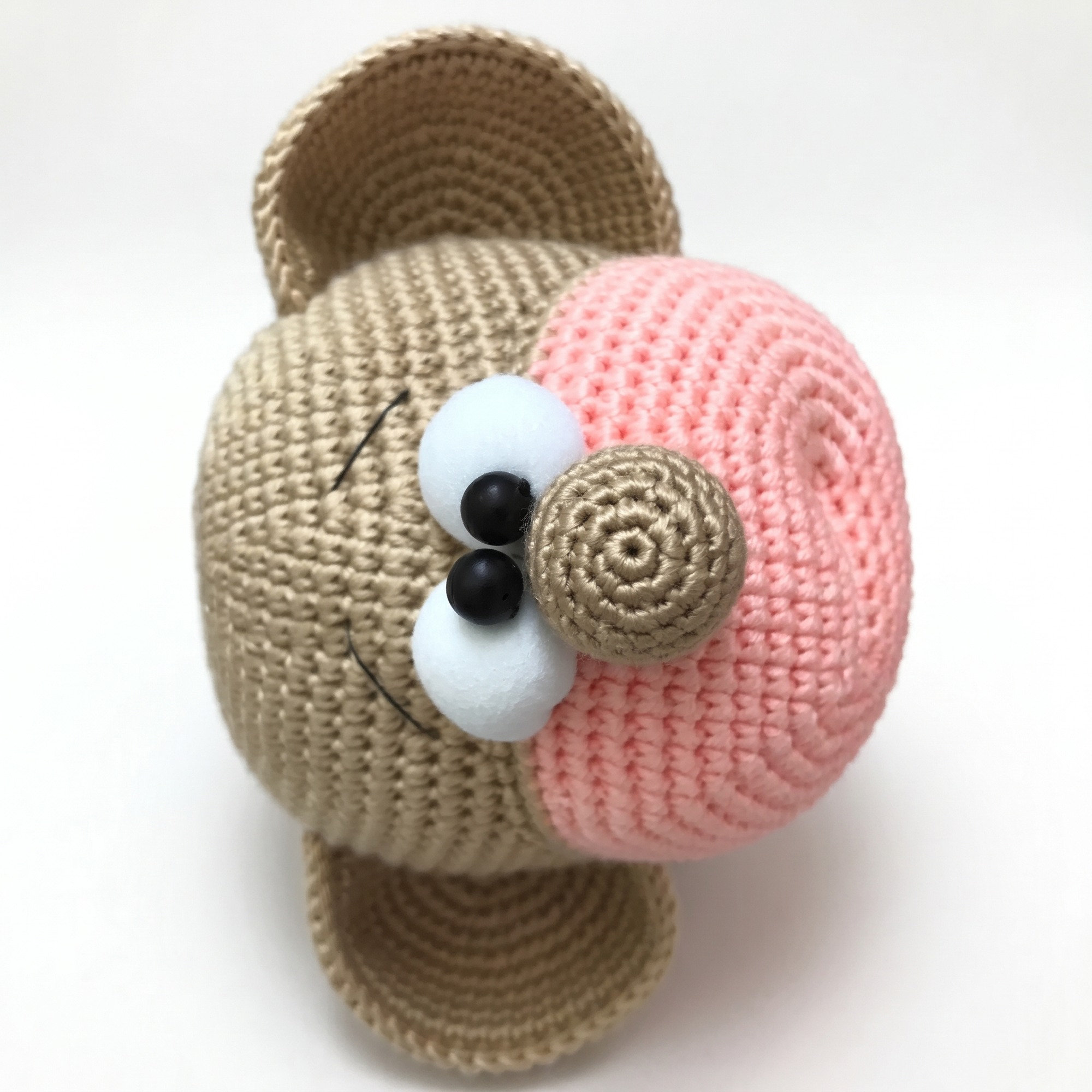 Close-up of the face, pink muzzle and eyes from the crochet monkey pattern